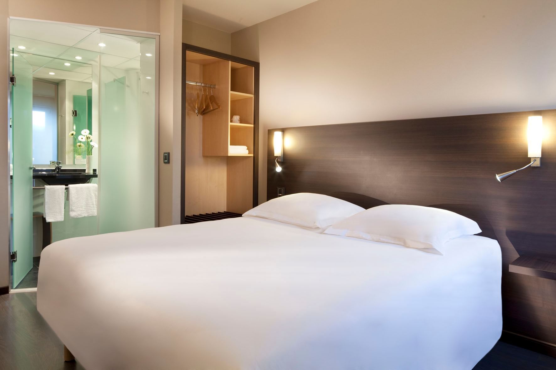 Lit, salle de bain et placard dans une chambre à Oceania Hotels