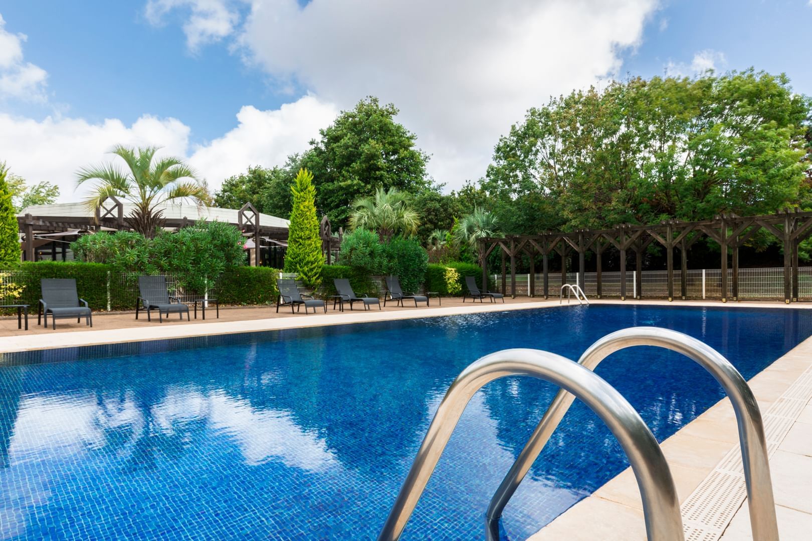 Chaises longues près de la piscine extérieure aux Oceania Hotels