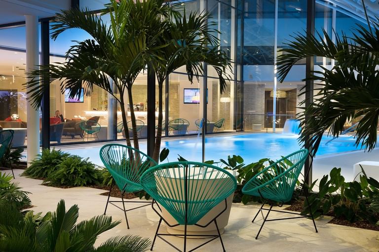Outdoor pool with palm trees at Oceania Paris Roissy CDG
