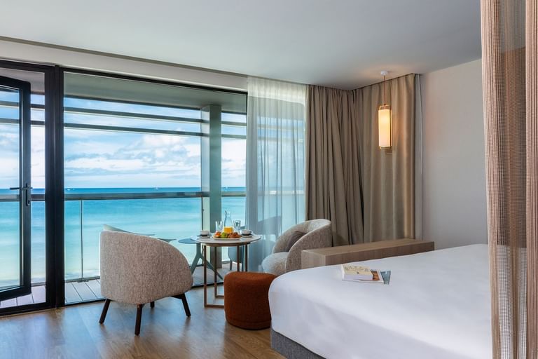 Salle à manger près du lit douillet dans la chambre Evasion avec vue sur l'océan à l'Oceania Saint-Malo