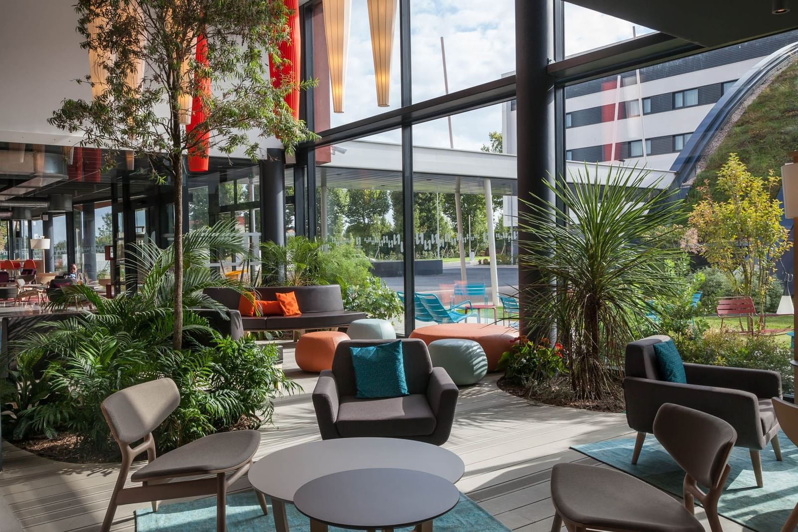 La zone de hall élégante avec des canapés et des chaises confortables disposés au Nomad Hotels Paris Roissy